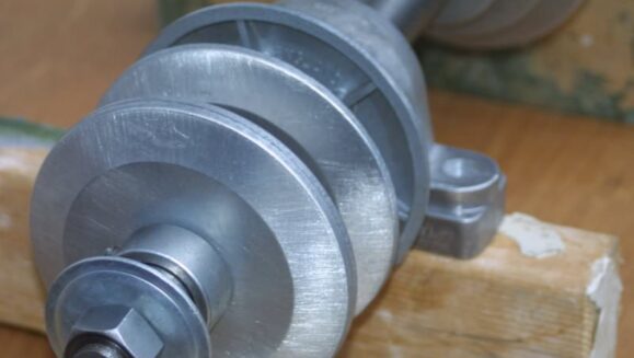 Details view of cabing machine shaft showing threaded end with nut